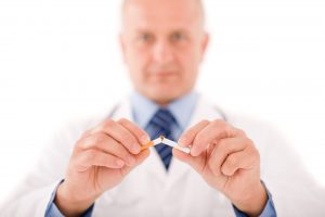 Stop smoking mature doctor male breaks cigarette focus on hand