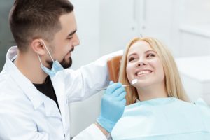 A dentist examining a patient in the chair