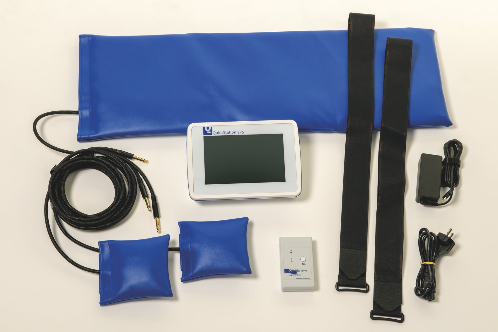 Everything supplied with the QuintStation 325 laid out: mat applicator, two pad applicators, cables, magnetic field tester, straps, power adapter and mains lead