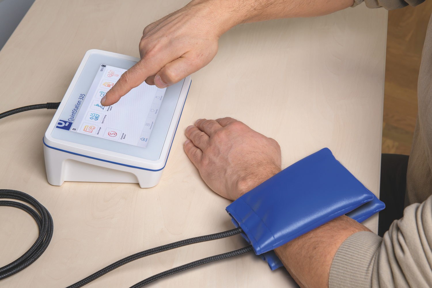 A practitioner selecting a programme while a P1 pad applicator is strapped to a client&rsquo;s forearm